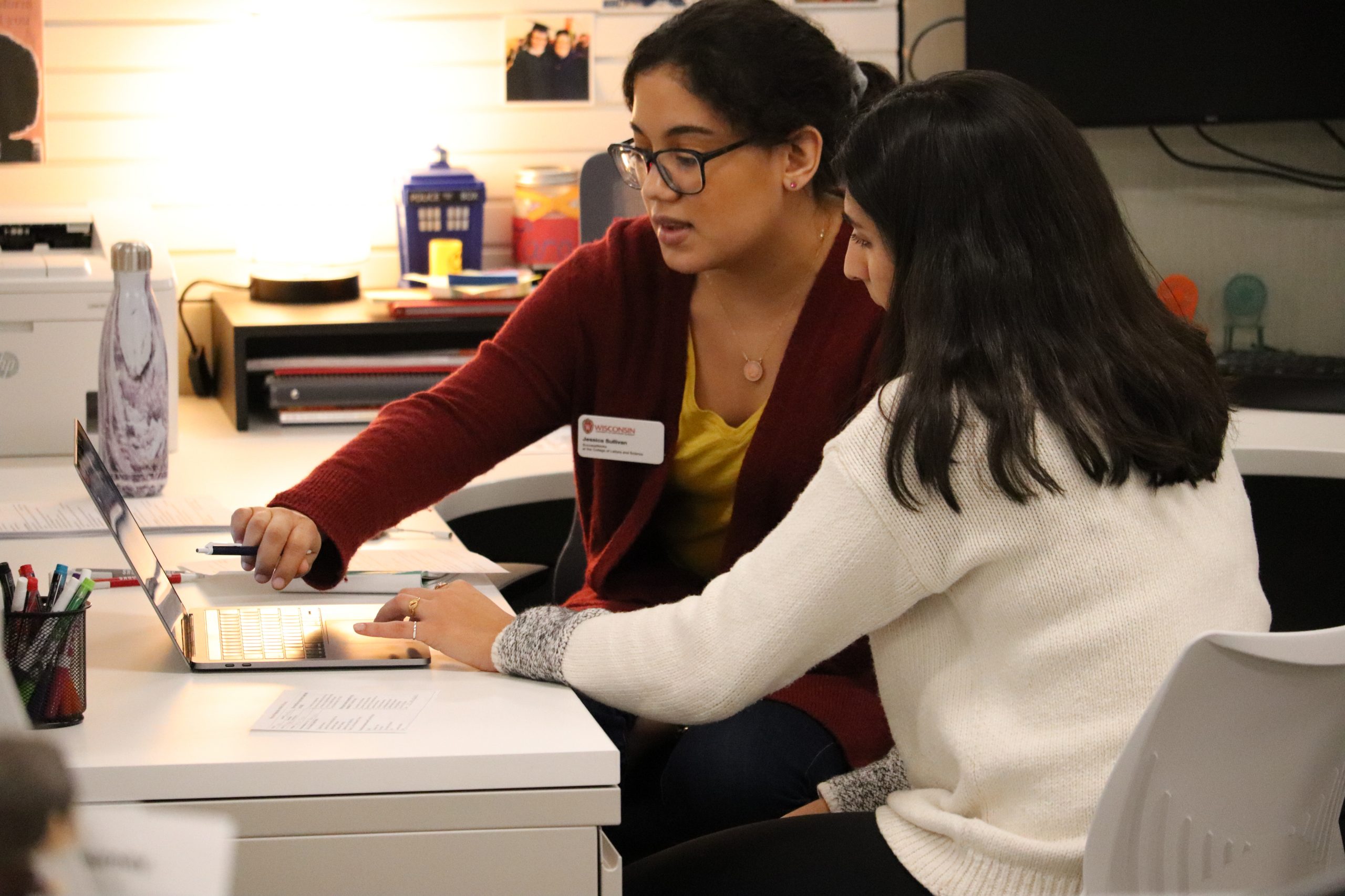 A Successworks employee showing a student something on a computer screen